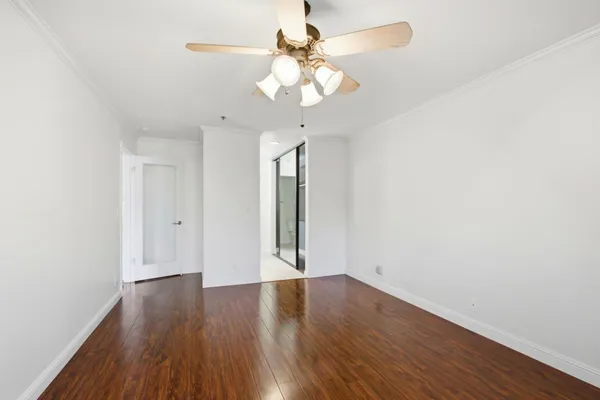 a view of wooden floor and a chandelier fan in a room