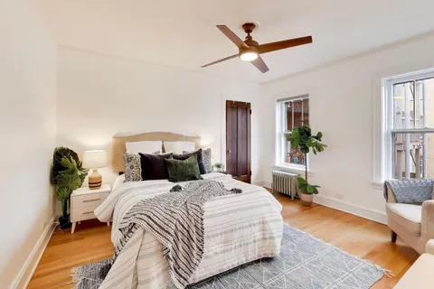 a bedroom with a bed and wooden floor