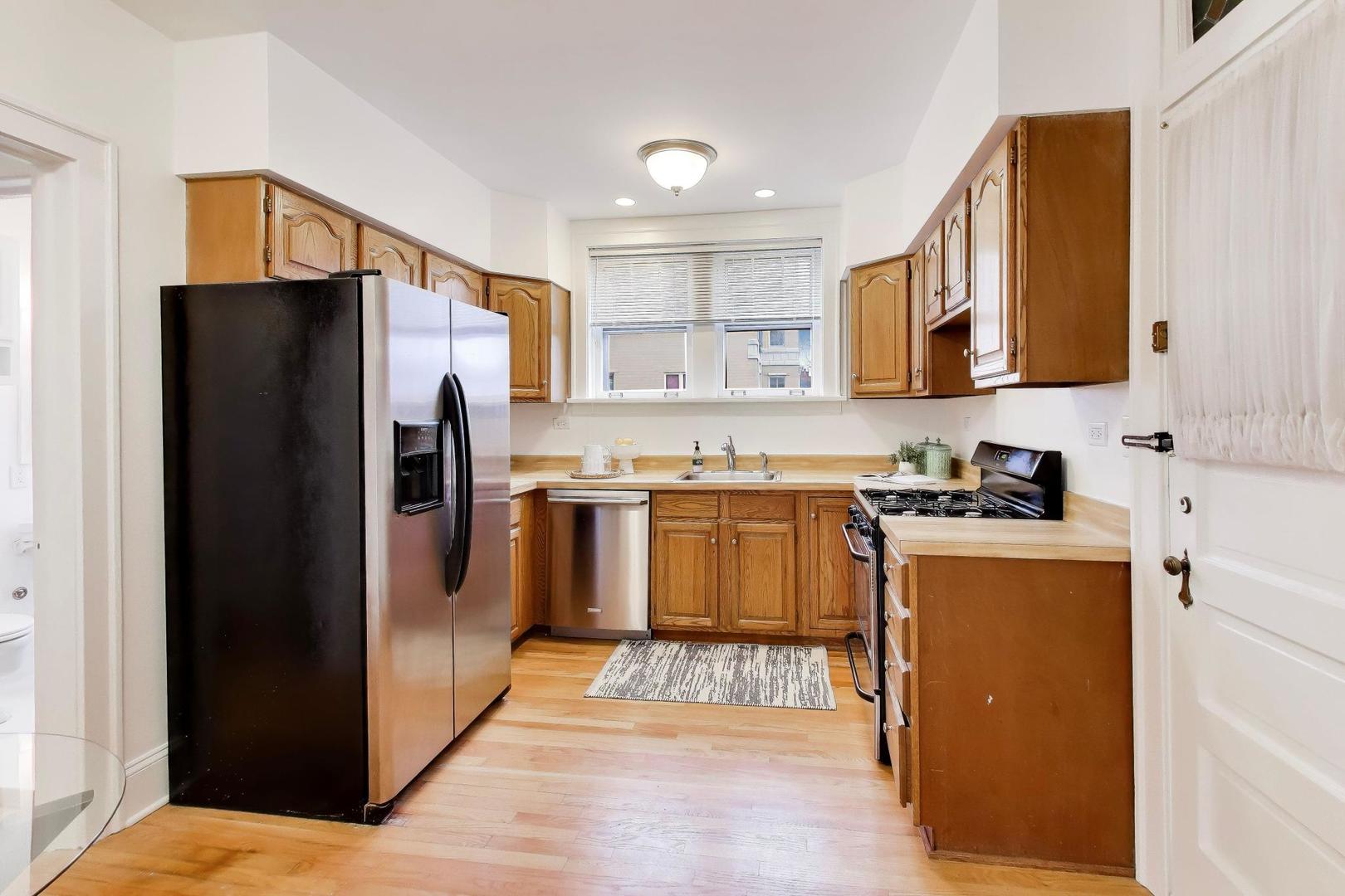 1929 Sherman Avenue, Unit 2W Evanston, IL 60201 - Photo 7 of 26 a kitchen with stainless steel appliances granite countertop a refrigerator sink and stove