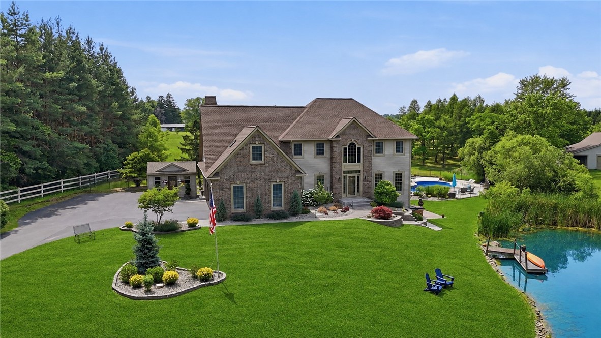2057 Stirnie Road Victor, NY 14564 - Photo 3 of 48 High-angle look at the main residence's stately facade, showing its close proximity to the scenic pond and pristine landscaping on this 5.10-acre estate!