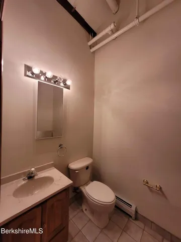 a bathroom with a granite countertop toilet and a sink