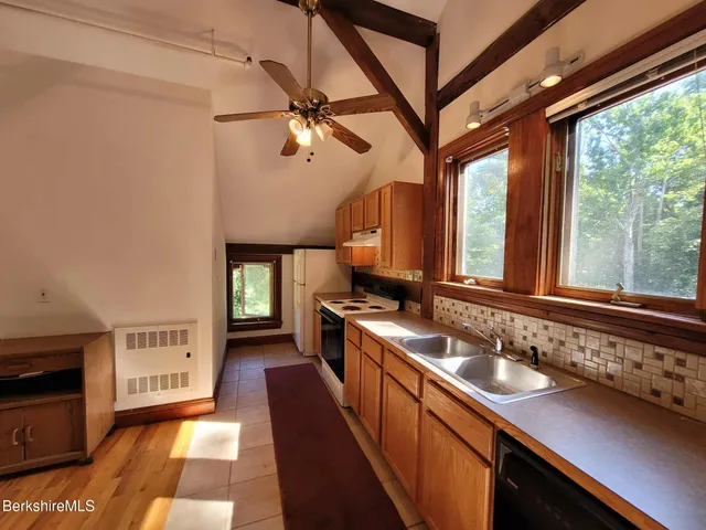 a kitchen with stainless steel appliances granite countertop a sink stove and cabinets