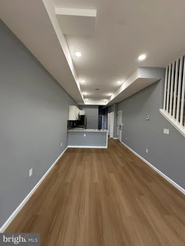 a view of empty room with wooden floor