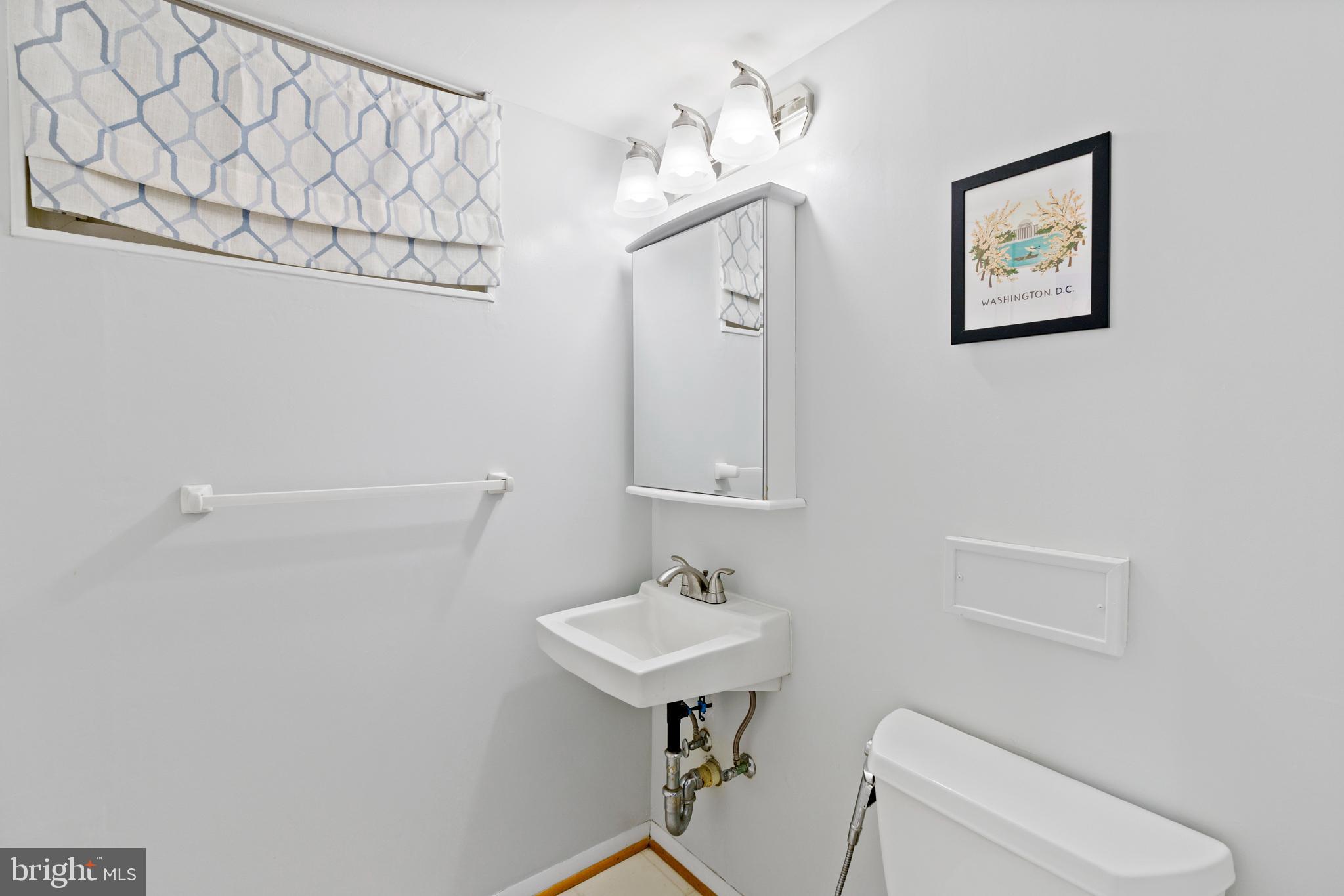 8608 Langport Drive Springfield, VA 22152 - Photo 34 of 43 a bathroom with a toilet a sink and mirror