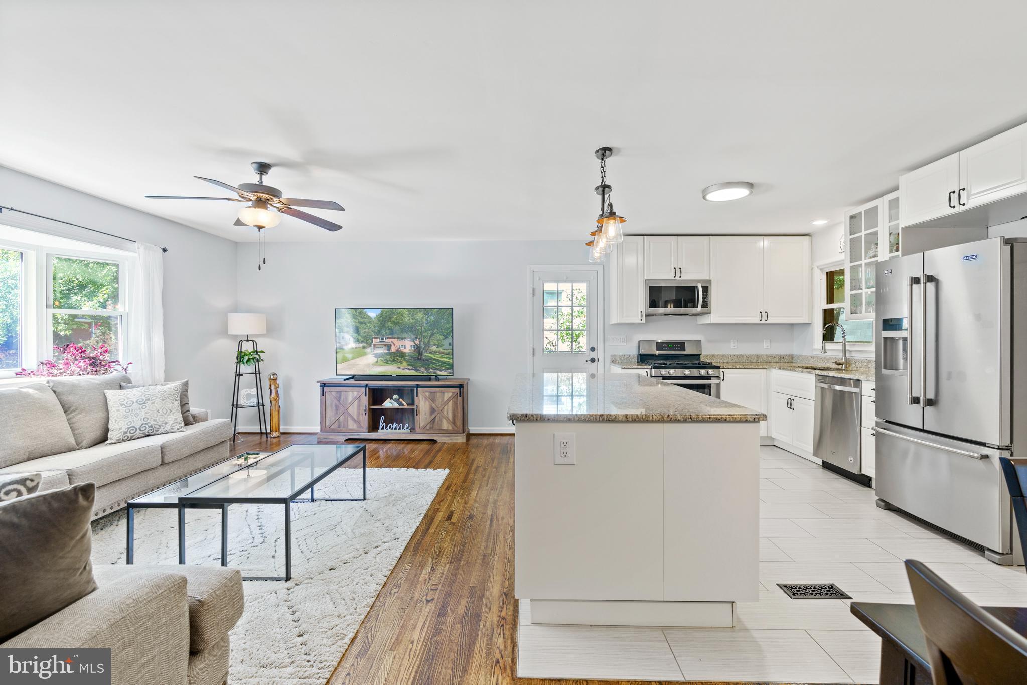 8608 Langport Drive Springfield, VA 22152 - Photo 9 of 43 a living room with stainless steel appliances furniture a rug and a kitchen view