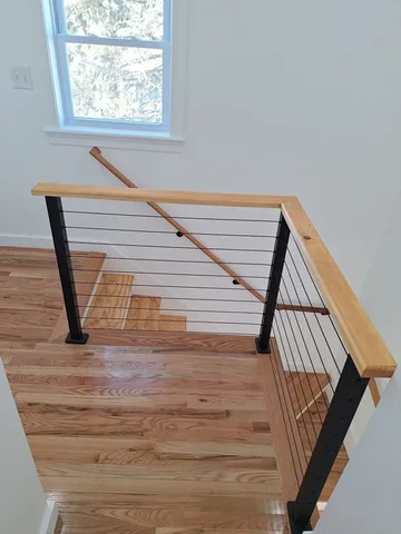 a view of staircase with white walls and a window