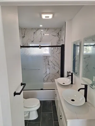 a bathroom with a sink a toilet and mirror