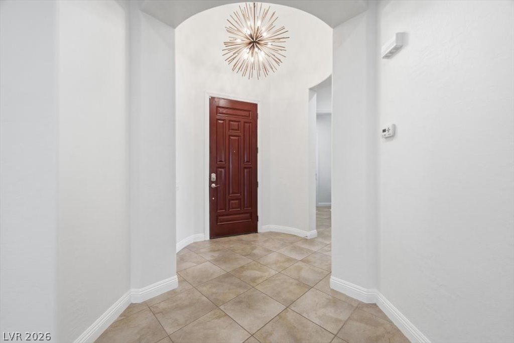 2125 De Rouge Avenue Henderson, NV 89044 - Photo 8 of 96 A stylish Sputnik chandelier illuminates the welcoming entry with its paneled mahogany door.