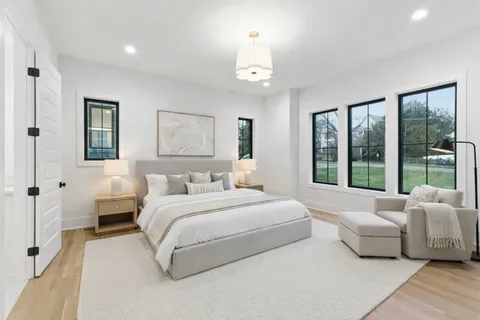 a kitchen with kitchen island stainless steel appliances a dining table chairs sink and wooden floor