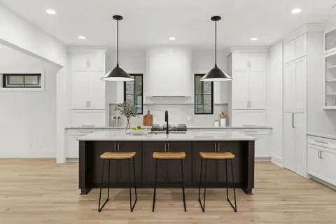 a kitchen with kitchen island a sink stainless steel appliances and cabinets