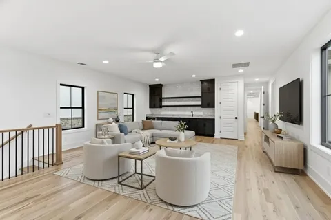 a living room with kitchen island granite countertop furniture and a chandelier