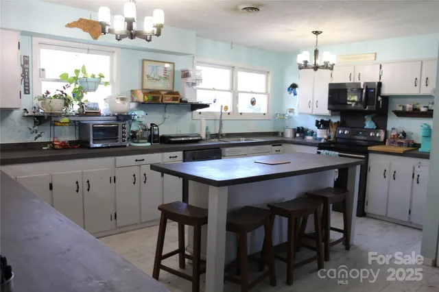 a kitchen with kitchen island granite countertop a sink cabinets and stainless steel appliances