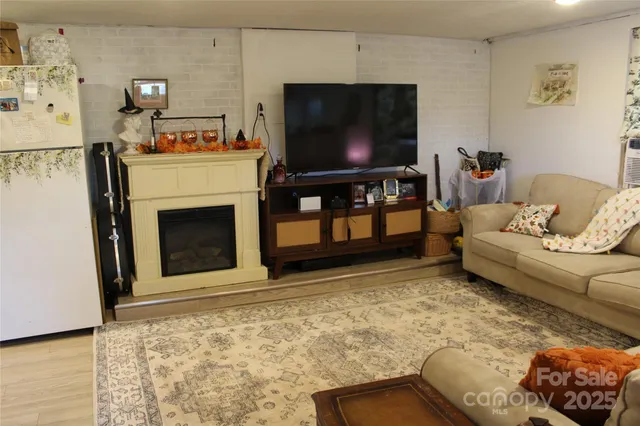 a living room with stainless steel appliances kitchen island granite countertop furniture and a wooden floor