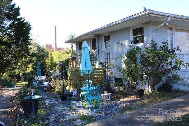 a view of a patio with table and chairs potted plants with floor to ceiling window