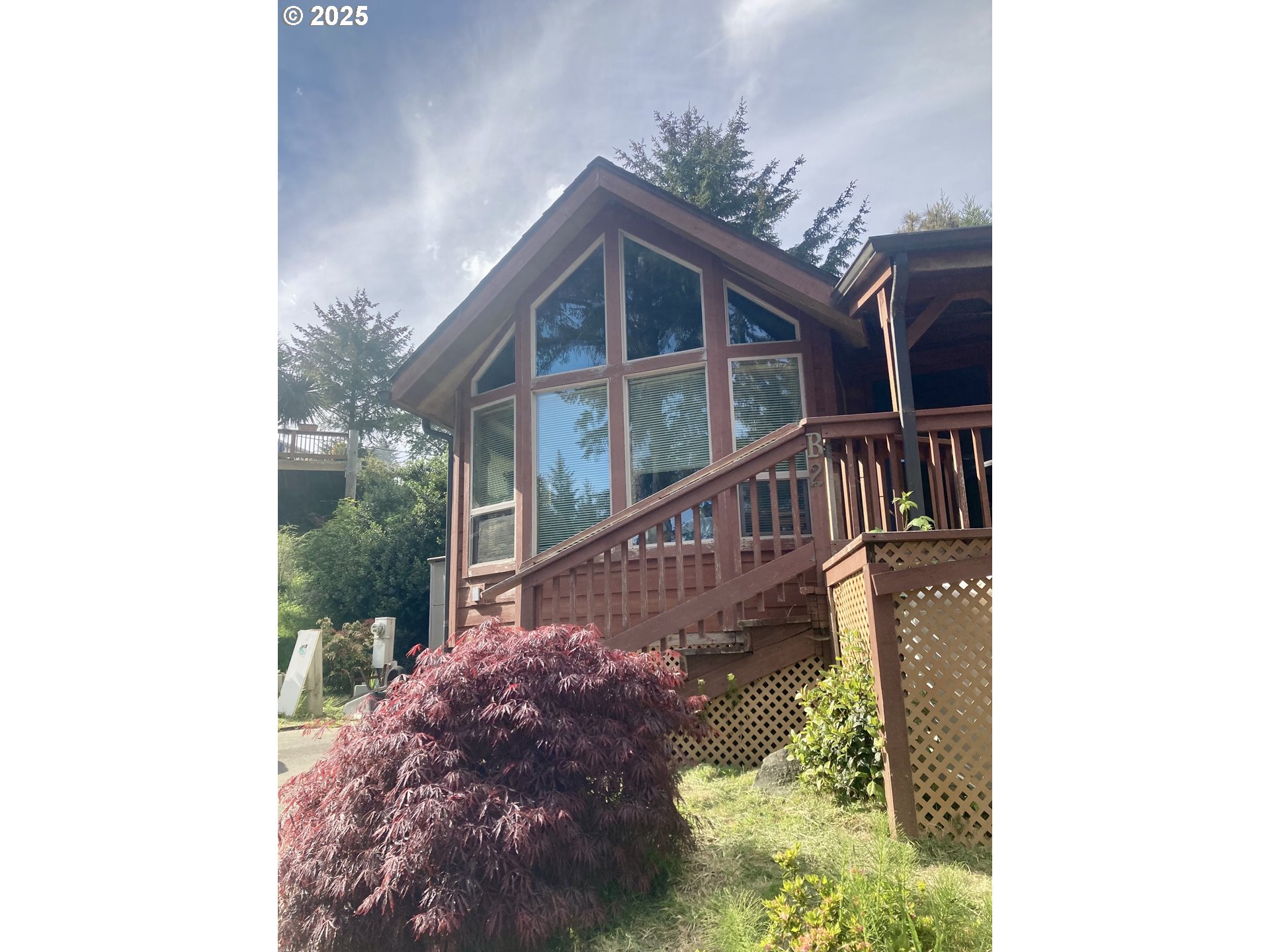 a view of a house with a small yard and floor to ceiling window