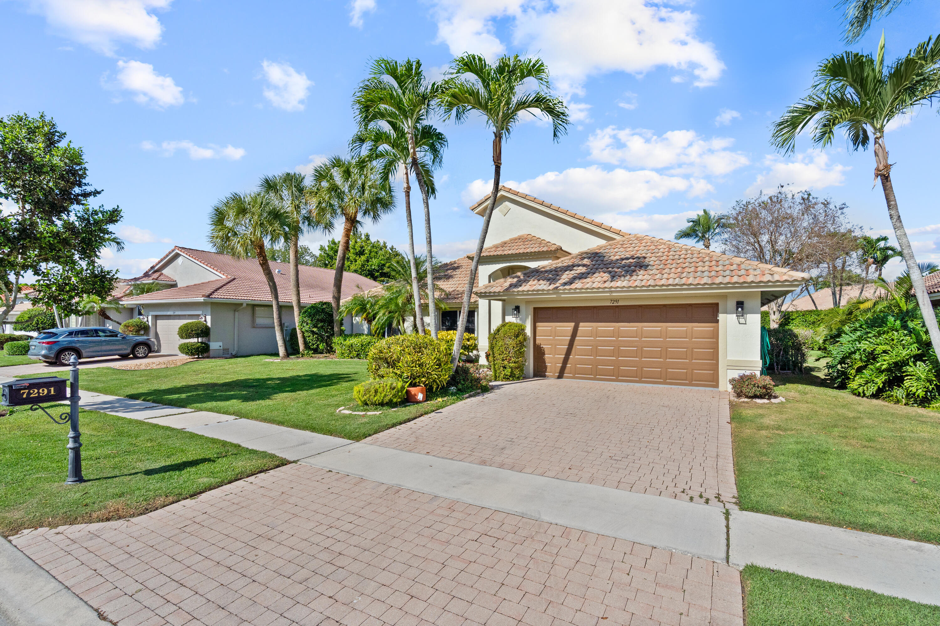 7291 Falls Road East Boynton Beach, FL 33437 - Photo 2 of 26 a front view of a house with a yard and garage