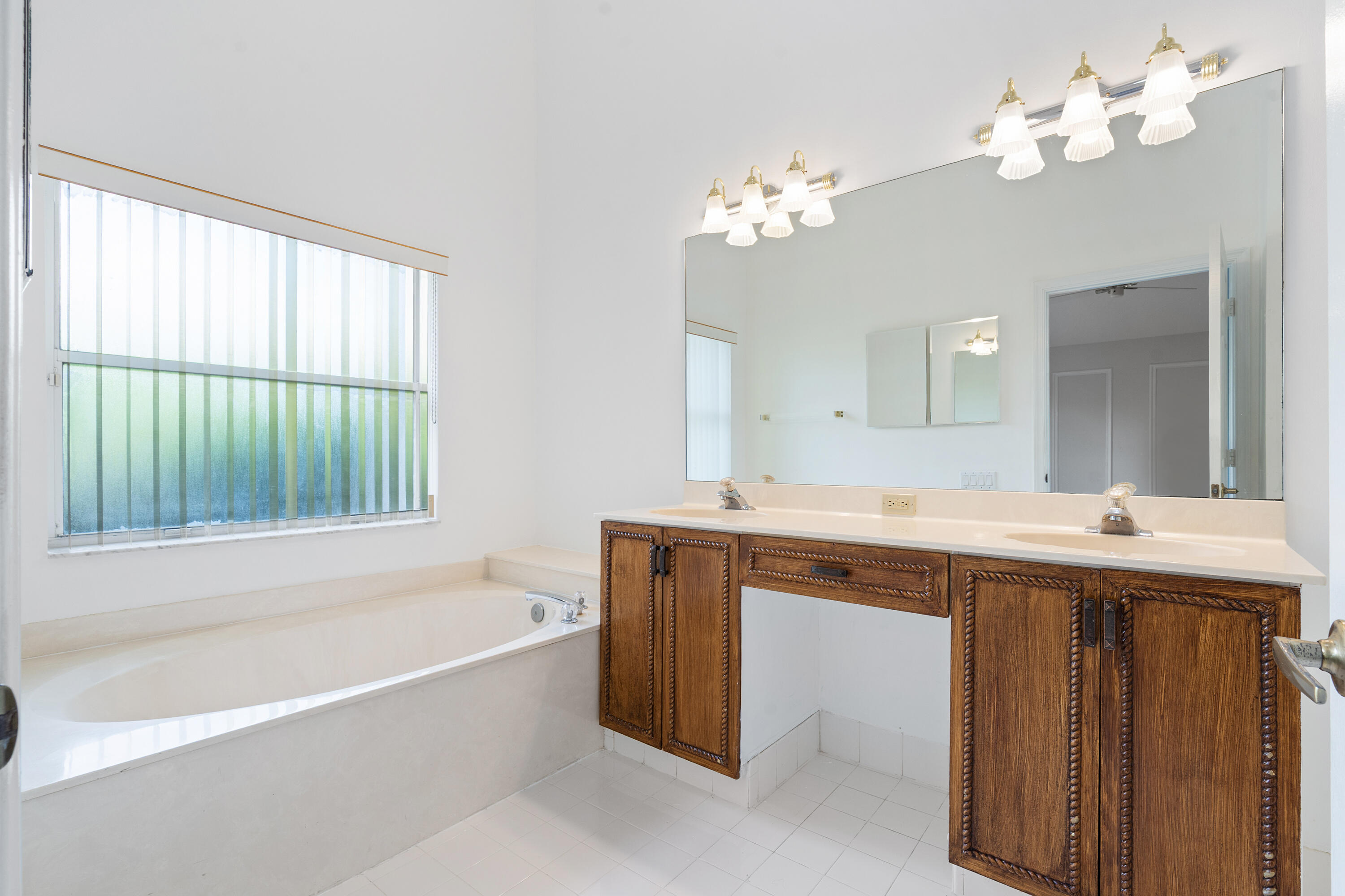 7291 Falls Road East Boynton Beach, FL 33437 - Photo 22 of 26 a spacious bathroom with a tub double sink and mirror