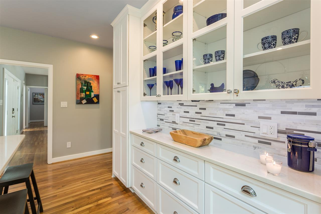 4409 Wood Valley Drive Raleigh, NC 27613 - Photo 12 of 30 Tile Backsplash, Quartz Countertops, and Under Cabinet Lighting Wall of Glass Cabinets