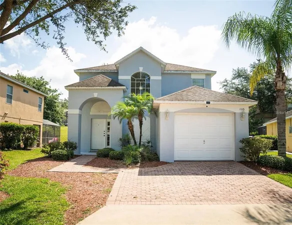 a view of a white house with a yard and palm trees