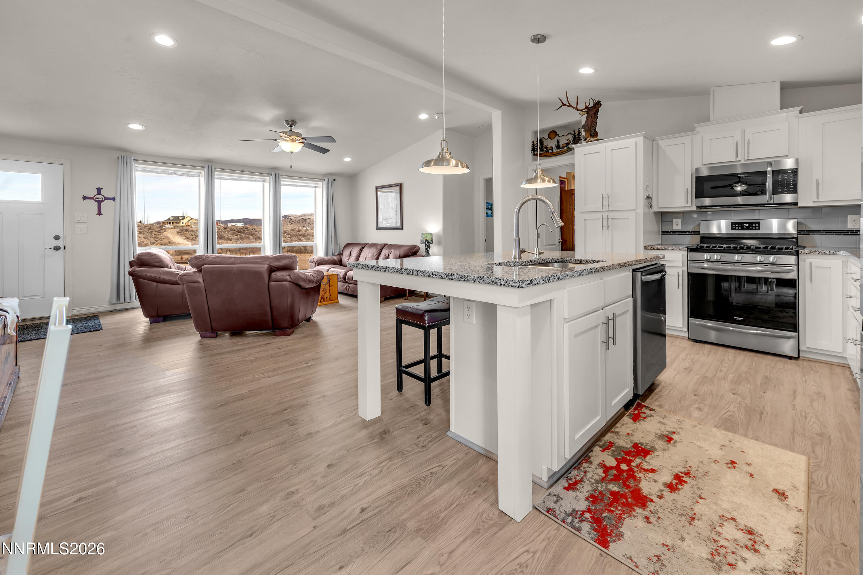 105 Arabian Way Reno, NV 89508 - Photo 12 of 40 a kitchen with stainless steel appliances kitchen island granite countertop a stove and a wooden floors