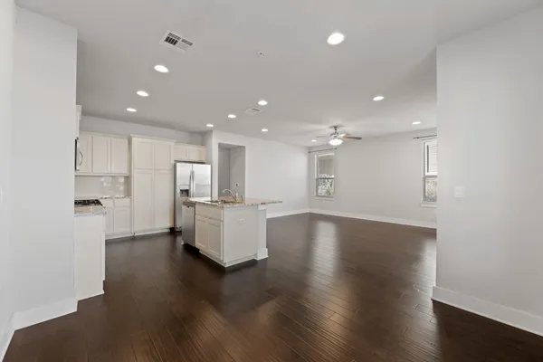 a view of kitchen with kitchen island refrigerator wooden floor and center island
