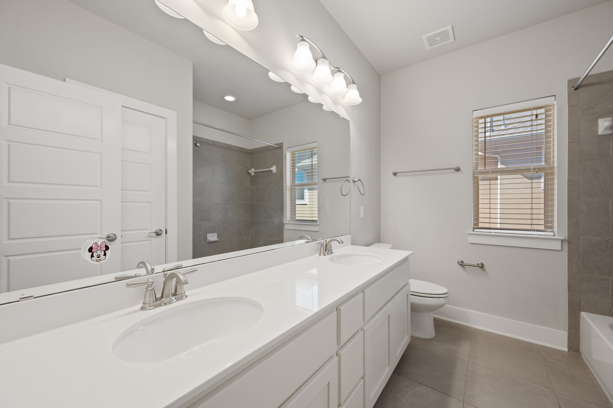 13800 Lyndhurst Street, Unit 326 Austin, TX 78717 - Photo 28 of 39 a bathroom with a double vanity sink a toilet and a mirror