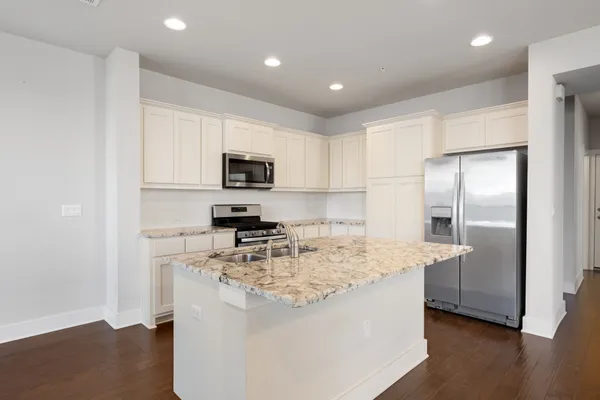 a kitchen with kitchen island a counter top space cabinets stainless steel appliances and a counter space