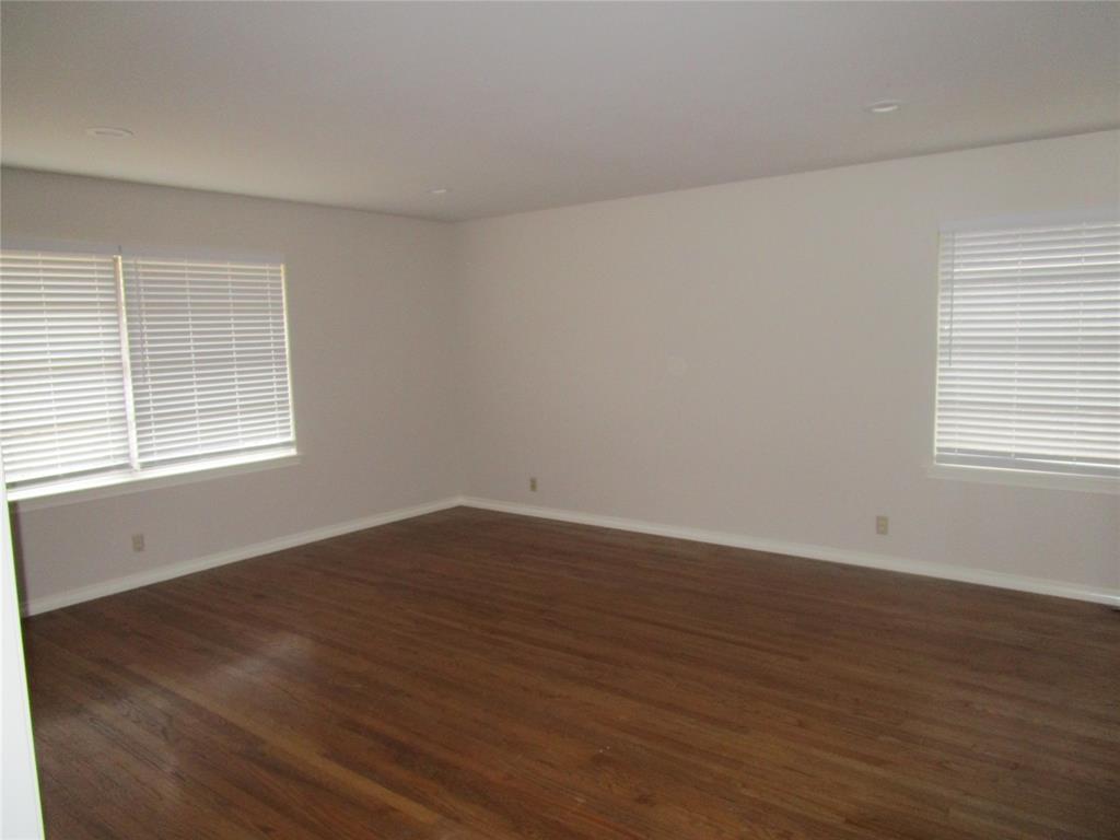 7128 Clemson Drive Dallas, TX 75214 - Photo 2 of 10 a view of an empty room with wooden floor and a window