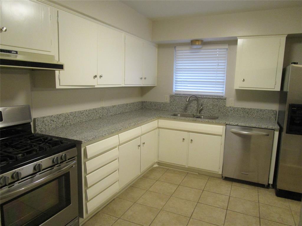 7128 Clemson Drive Dallas, TX 75214 - Photo 5 of 10 a kitchen with a sink stove and cabinets