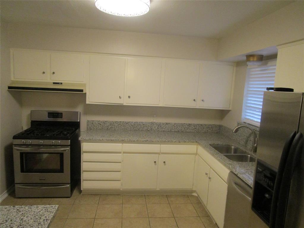 7128 Clemson Drive Dallas, TX 75214 - Photo 6 of 10 a kitchen with a sink stove and cabinets