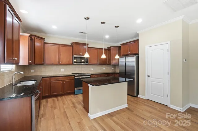 a kitchen with stainless steel appliances granite countertop a sink stove and refrigerator