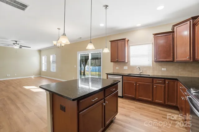 a kitchen with granite countertop a sink cabinets and window