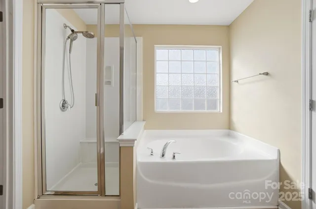 a white bath tub sitting next to a shower