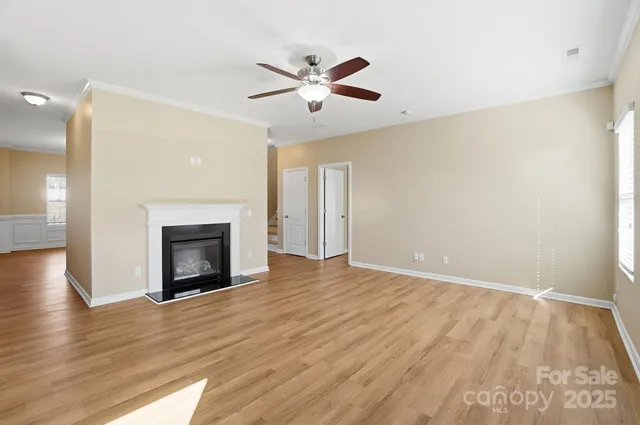 a view of empty room with wooden floor and fireplace