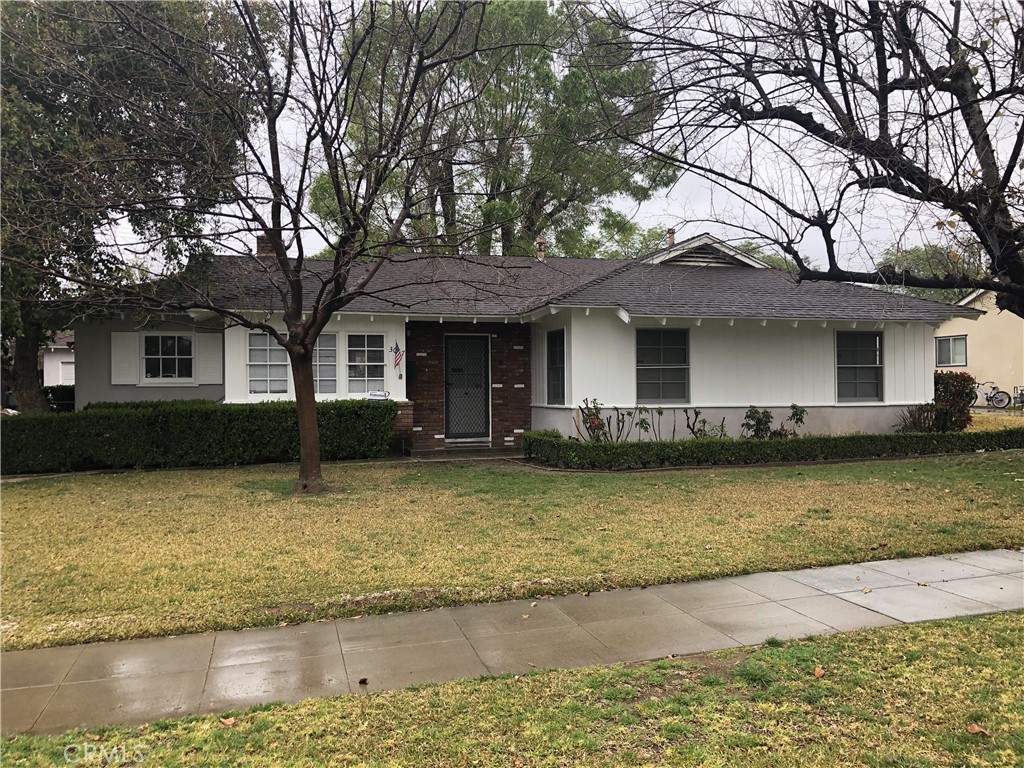 3067 Westridge Road Riverside, CA 92506 - Photo 1 of 1 a front view of a house with swimming pool and large trees