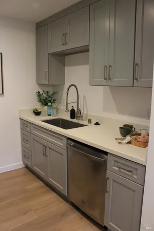 a kitchen with white cabinets and sink