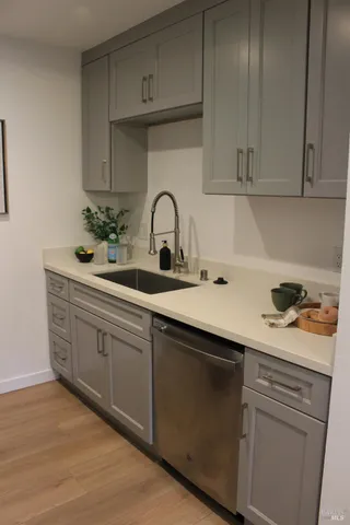 a kitchen with white cabinets and sink