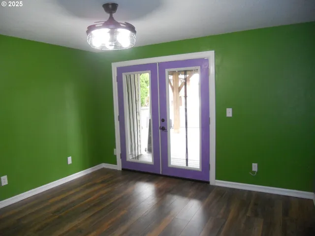 a view of empty room with window and wooden floor
