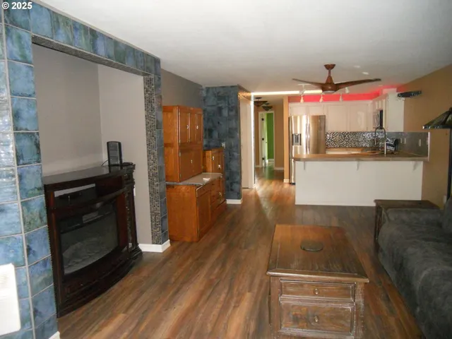 a kitchen view with wooden floor and electronic appliances