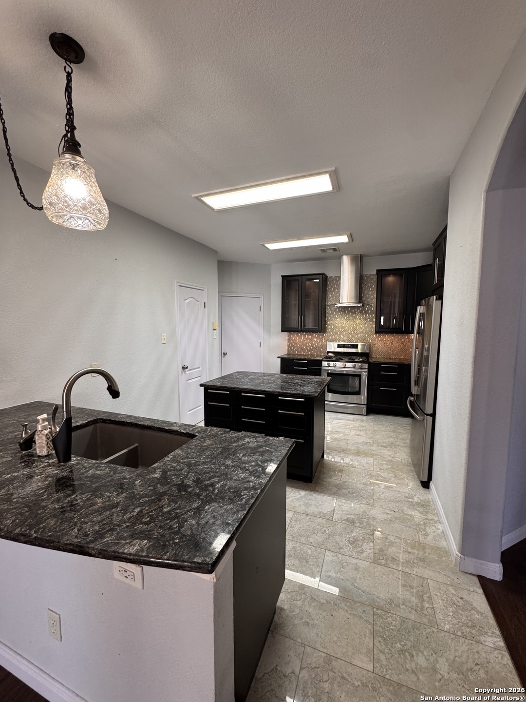 3836 Laurel Ridge Drive Round Rock, TX 78665 - Photo 12 of 40 a kitchen with granite countertop stainless steel appliances a sink dishwasher a refrigerator a stove top oven and a sink with granite countertops