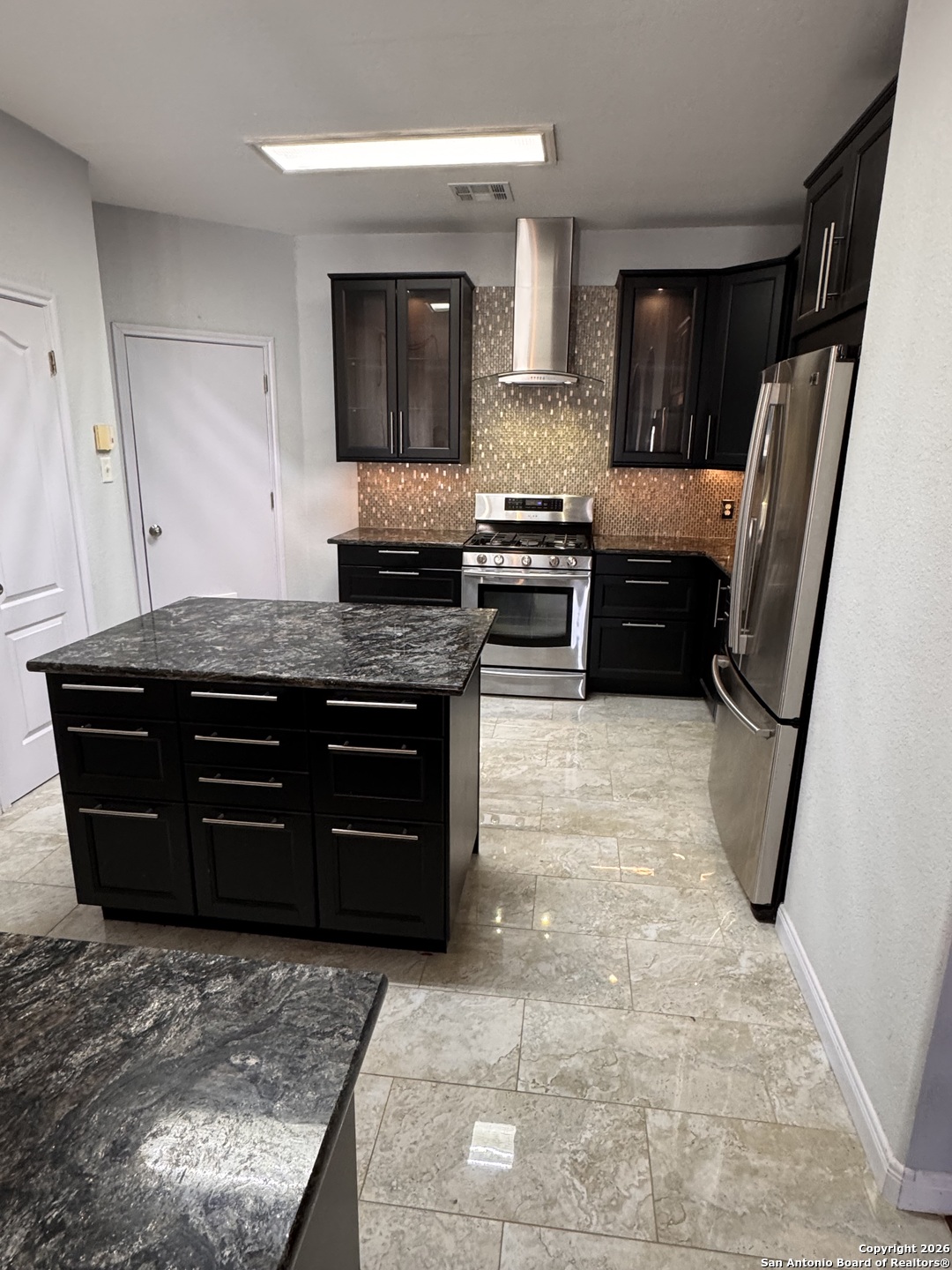 3836 Laurel Ridge Drive Round Rock, TX 78665 - Photo 5 of 40 a kitchen with stainless steel appliances granite countertop a stove a sink and a microwave