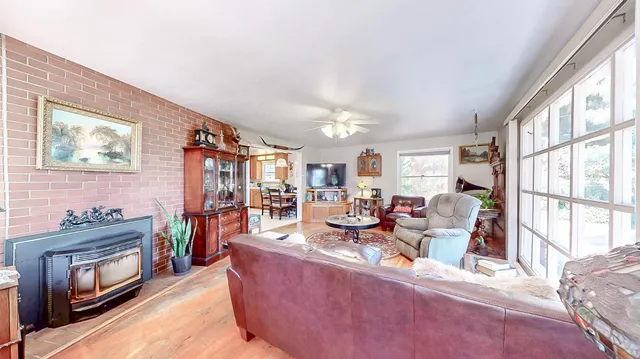 a living room with furniture a fireplace and a large window