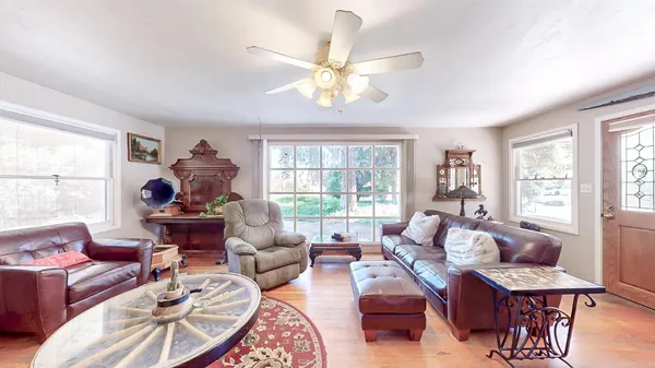 a living room with furniture and a wooden floor
