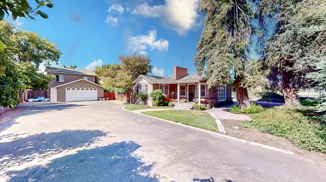 a front view of a house with a yard and potted plants