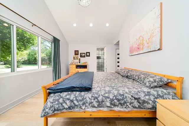 a bedroom with a bed and a large window