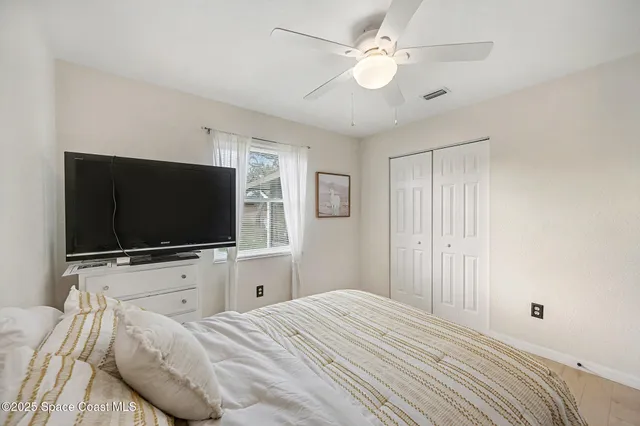 a bedroom with a bed tv and a window