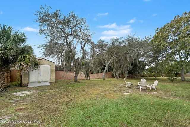 a backyard of a house with table and chairs