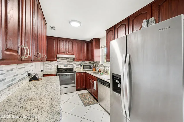 a kitchen with stainless steel appliances granite countertop a refrigerator sink and stove