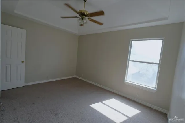an empty room with a window and a fan