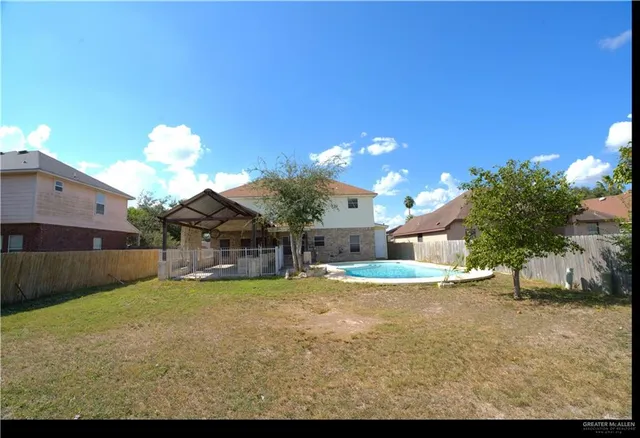 a view of a house with a yard and potted plants